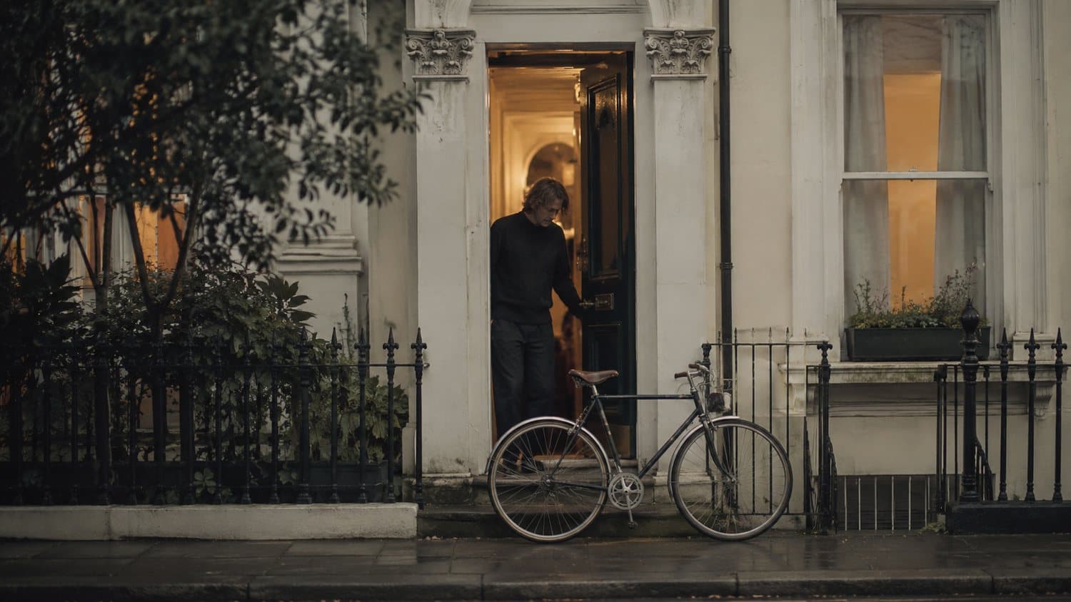 A rider stepping out to a bike returned to the doorway of a London terrace at first light