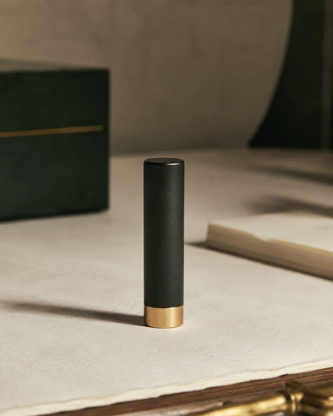 The assembled Elloowe tracker standing on cream paper with a brass end cap